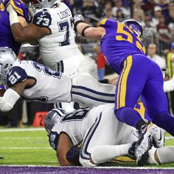 Dallas Cowboys running back Ezekiel Elliott (21) scores on a 1-yard touchdown run in front of Minnesota Vikings outside linebacker Chad Greenway (52) during the first half of an NFL football game Thursday, Dec. 1, 2016, in Minneapolis. 