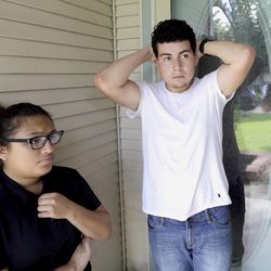 Viri Palacios, left, and her brother Miguel talk about the shooting deaths of their neighbors Thursday, July 10, 2014, in Spring, Texas. The Harris County Sheriff's Office says Ronald Lee Haskell was booked Thursday on a capital murder/multiple murders charge and held without bond. Authorities believe Haskell fatally shot two adults and four children on Wednesday night and critically wounded a 15-year-old girl, who called 911. (AP Photo/David J. Phillip)