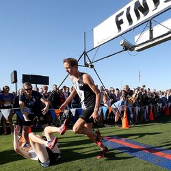 American Fork High School’s Ashton Hysell rolls after diving over the finish line to win the boys varsity 5K during the BYU Autumn Classic Cross Country Invitational at the East Bay Golf Course Saturday, Sept. 14, 2019 in Provo. Stansbury High’s Carson Belnap, right, took second place.