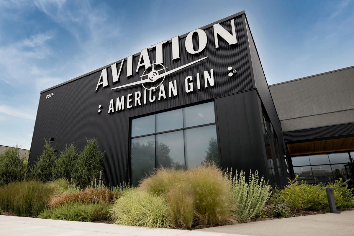 A black building with white lettering that reads “Aviation American Gin.”