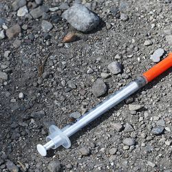 A syringe lays on the ground near the Rio Grande depot as the large police presence in the area has forced many of the homeless out in Salt Lake City on Wednesday, Aug. 16, 2017.