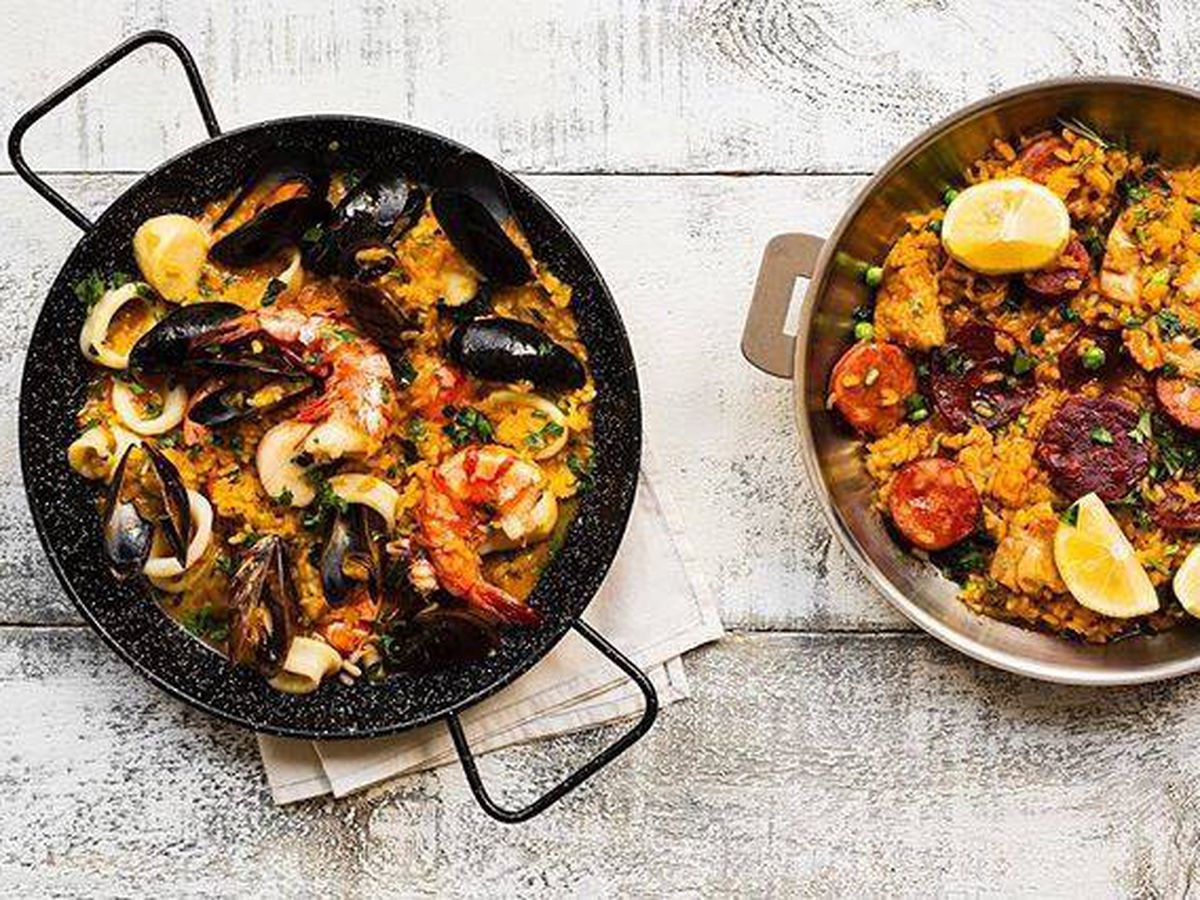Two bowls of paella on a white table. 