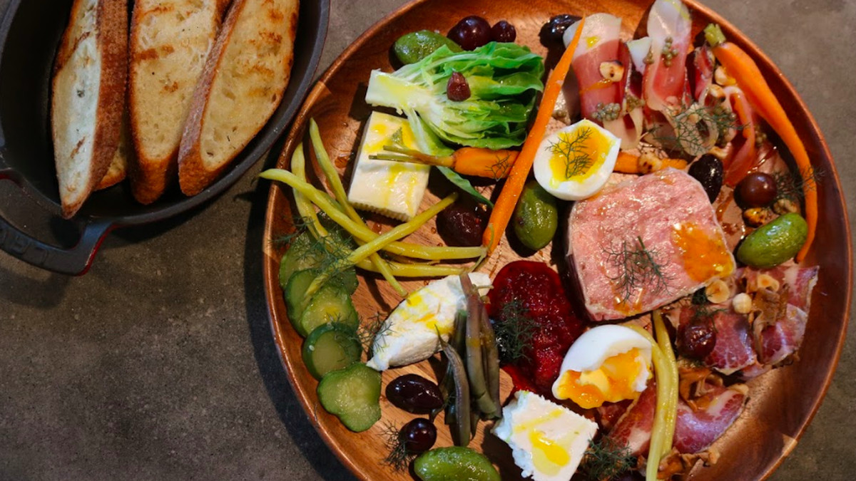 The Family Platter at the Deer and Dove in Decatur GA with cured salumi and cheeses, terrine, seasonal vegetables, soft boiled farm eggs and toasted baguette slices.