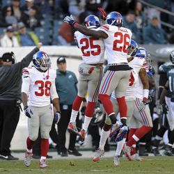 Will Hill (25) and Antrel rolle (26) celebrate Hill's game-clinching interception.