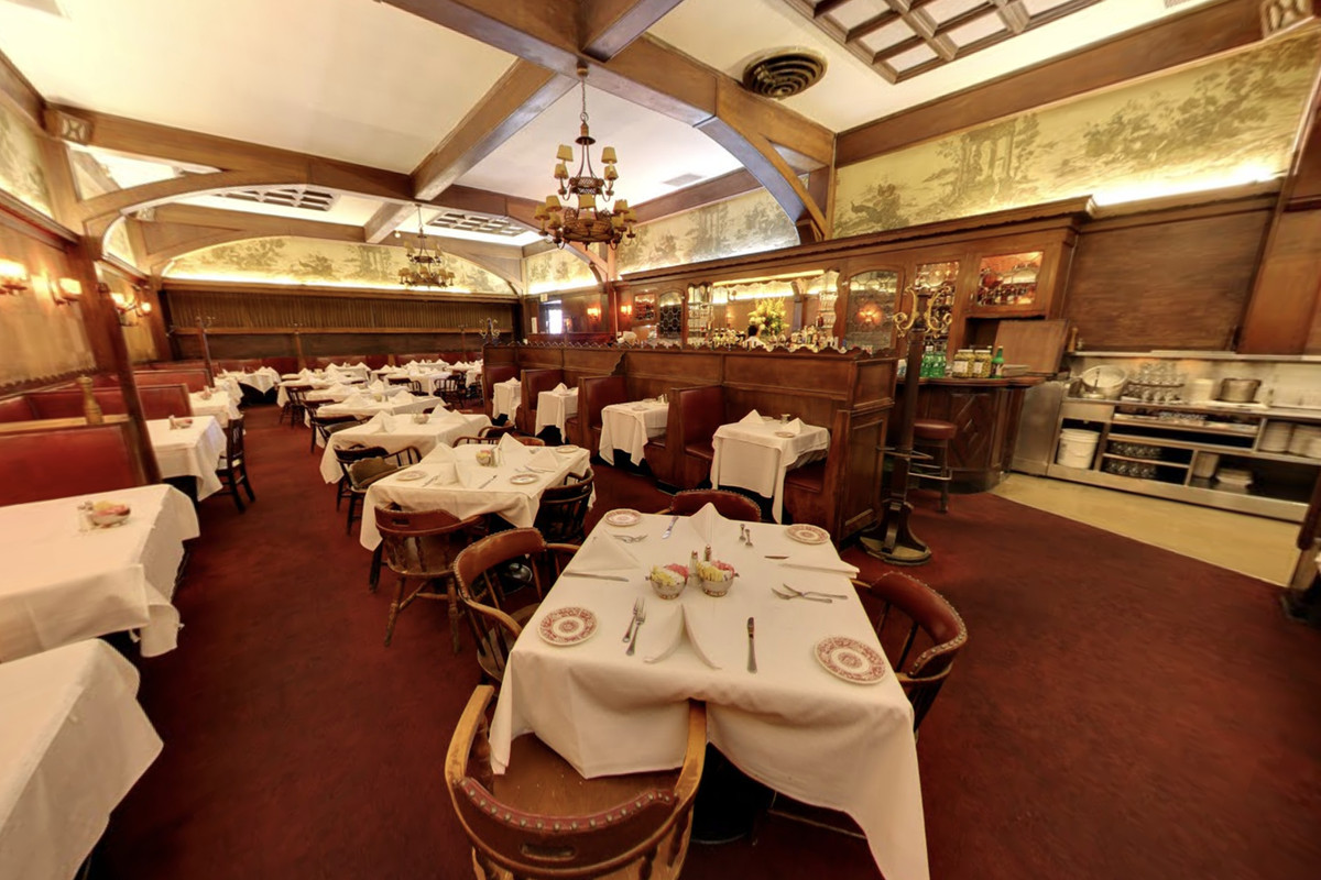 The deep walls and white tablecloths of a historic Hollywood restaurant.