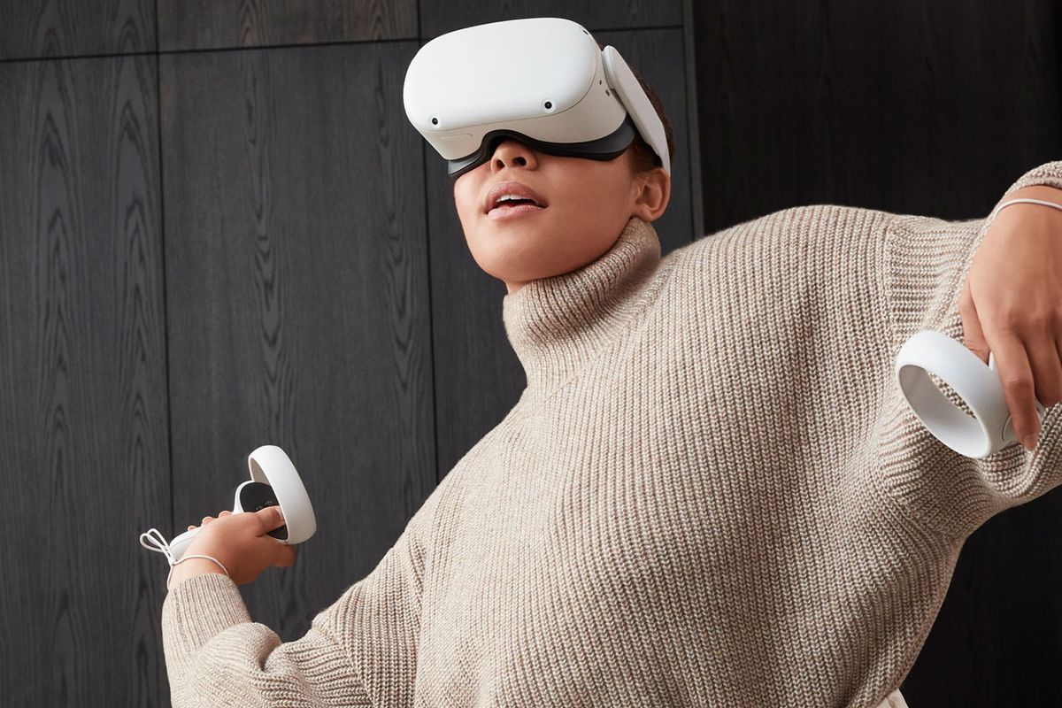 A woman wearing a turtleneck sweater plays with a Meta Quest 2 headset
