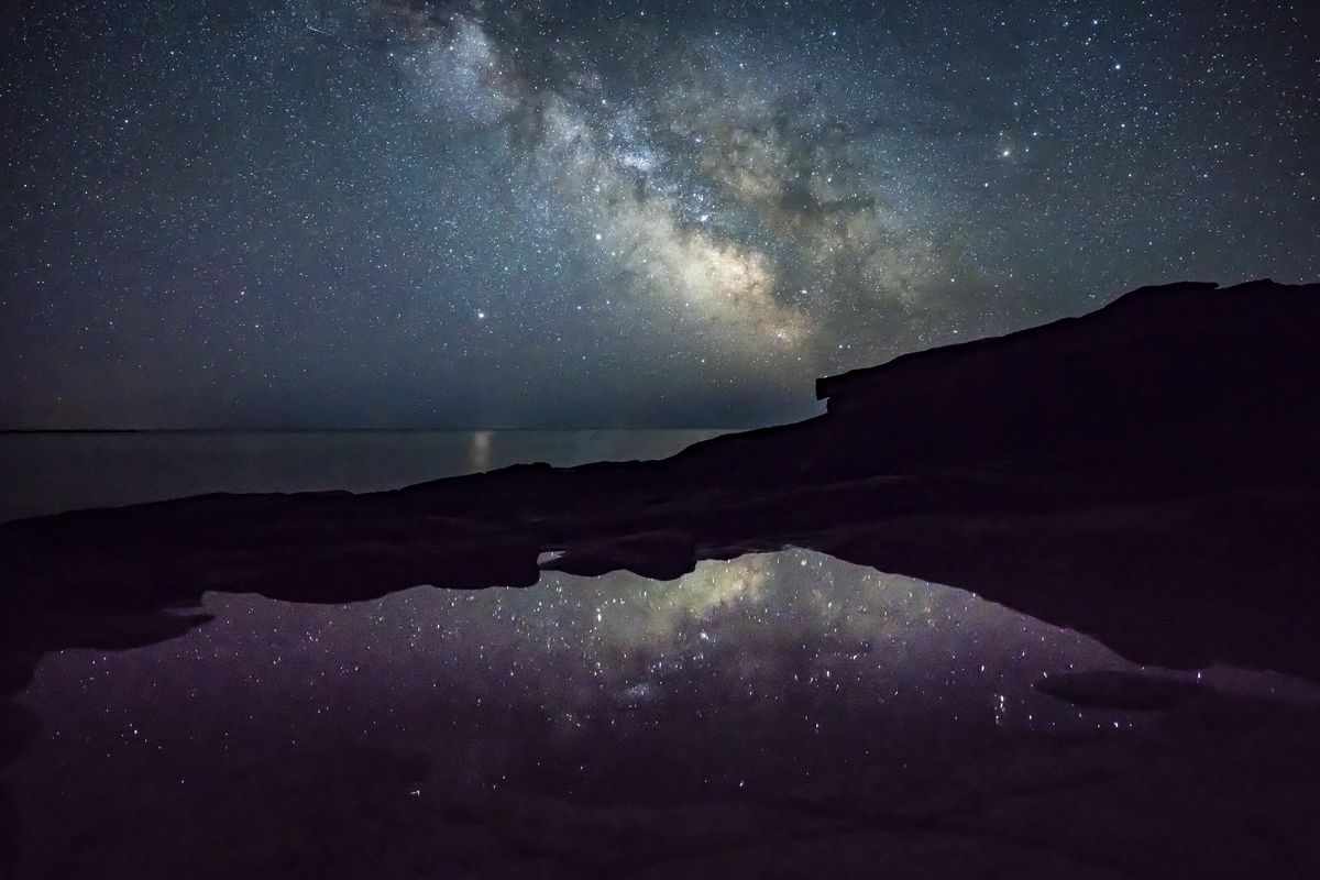 Milky Way and stars shine off the coast of Acadia National Park