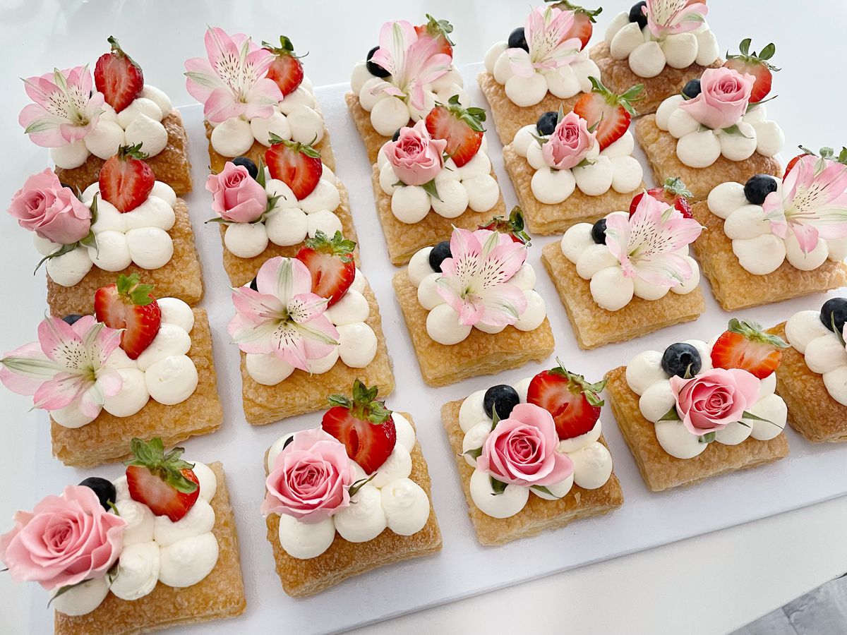 Mini pastries decorated with flowers and cream.