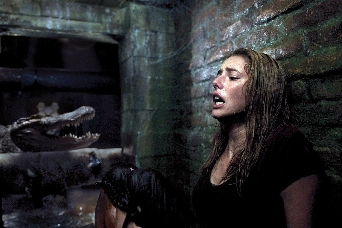 Kaya Scodelario as Haley recoiling in horror from an approaching alligator in Crawl.