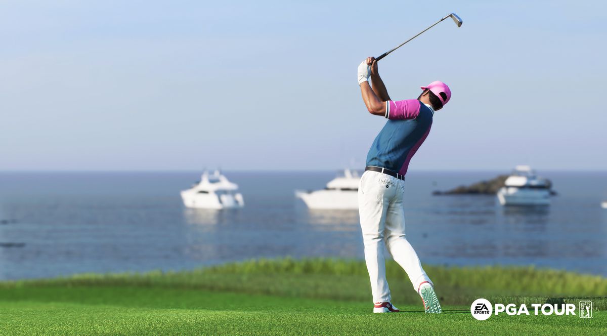 A golfer in a blue shirt and white pants swings an iron on the Pebble Beach fairway, with three yachts in the distance off the Monterey coastline, in EA Sports PGA Tour