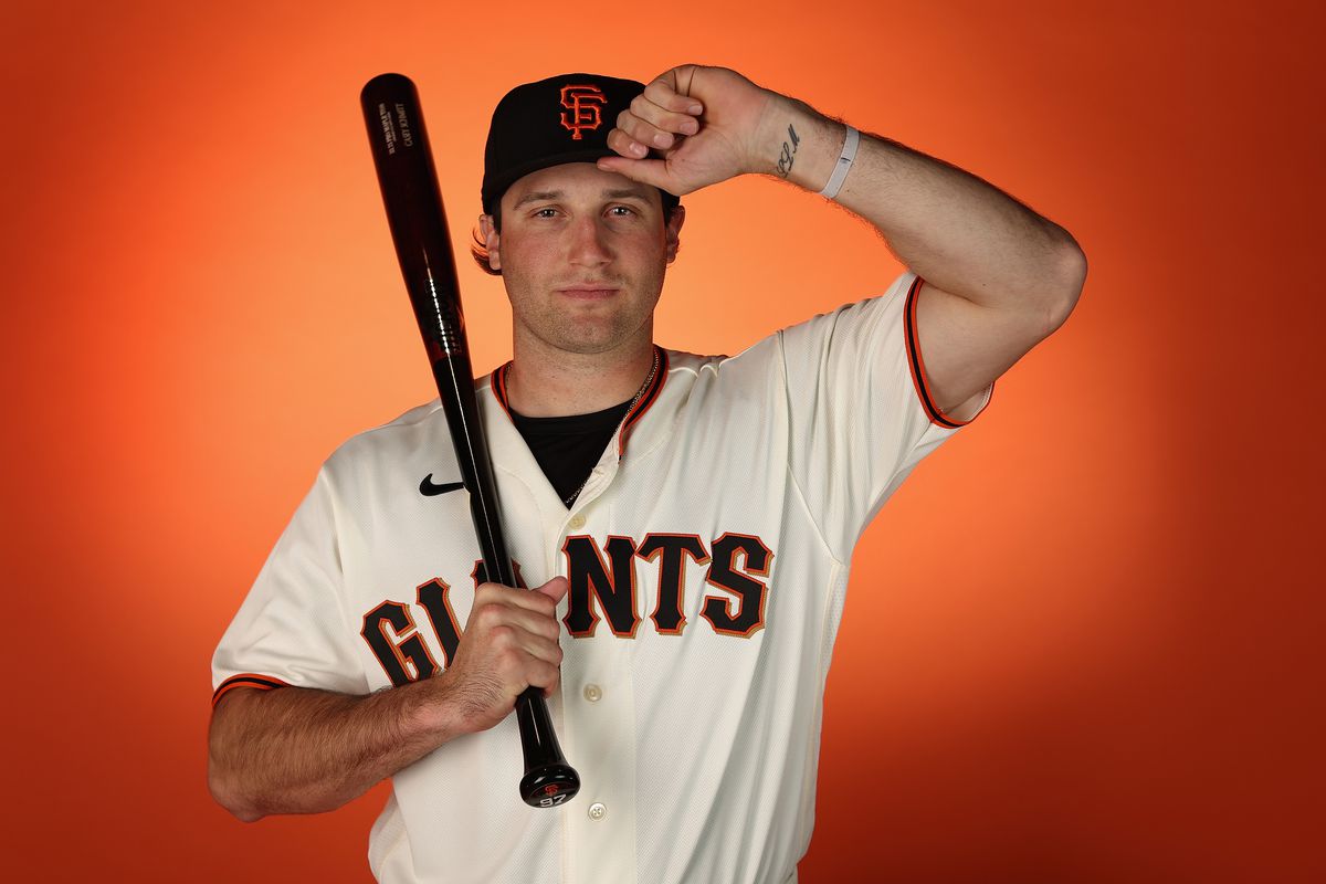 Casey Schmitt posing on media day with his bat on his shoulder, holding his cap