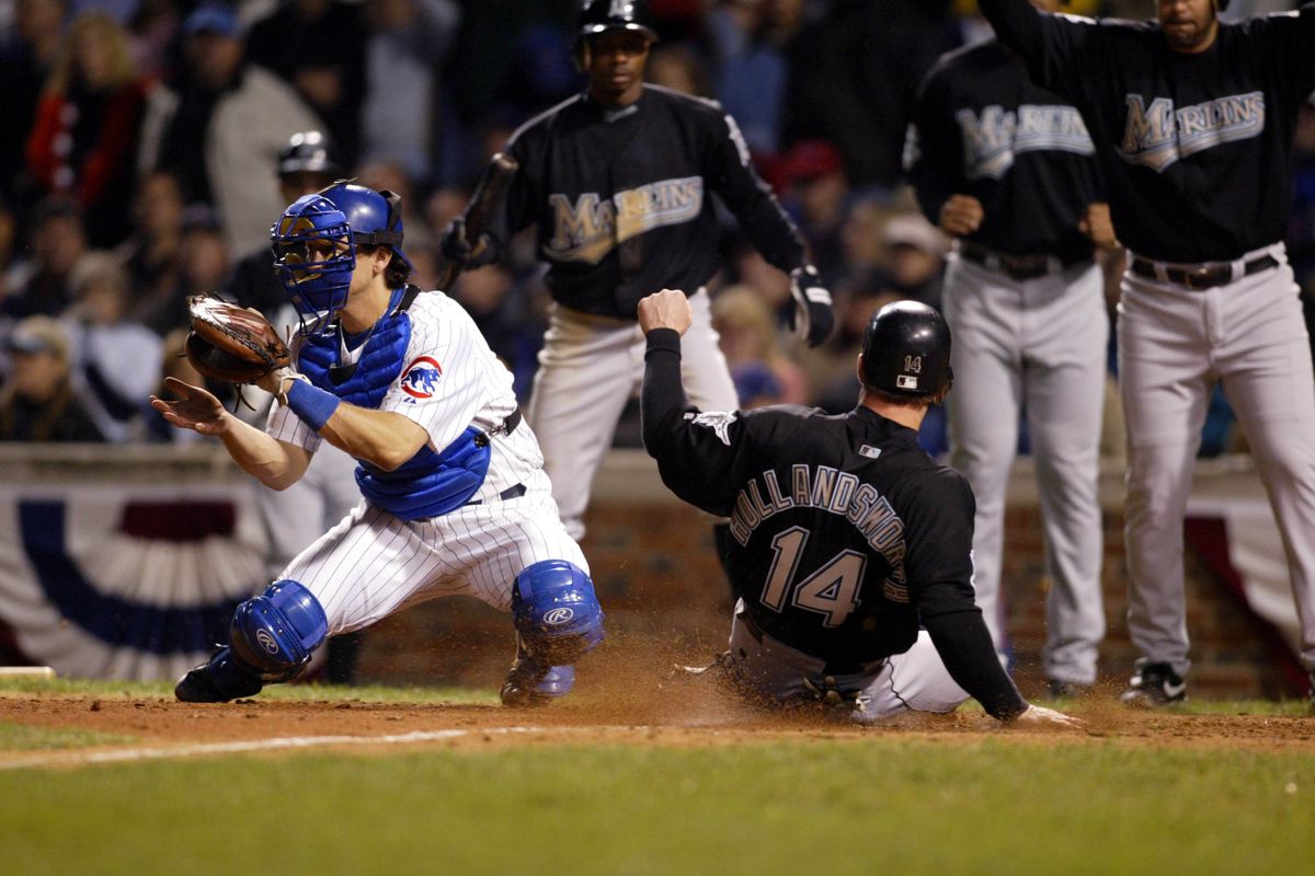 14 Oct 2003: Todd Hollandsworth of the Florida Marlins slides home safely ahead of the tag by the Cubs Paul Bako during the Marlins 8-3 victory over the Chicago Cubs in game 6 of the NLCS at Wrigley Field in Chicago, IL.