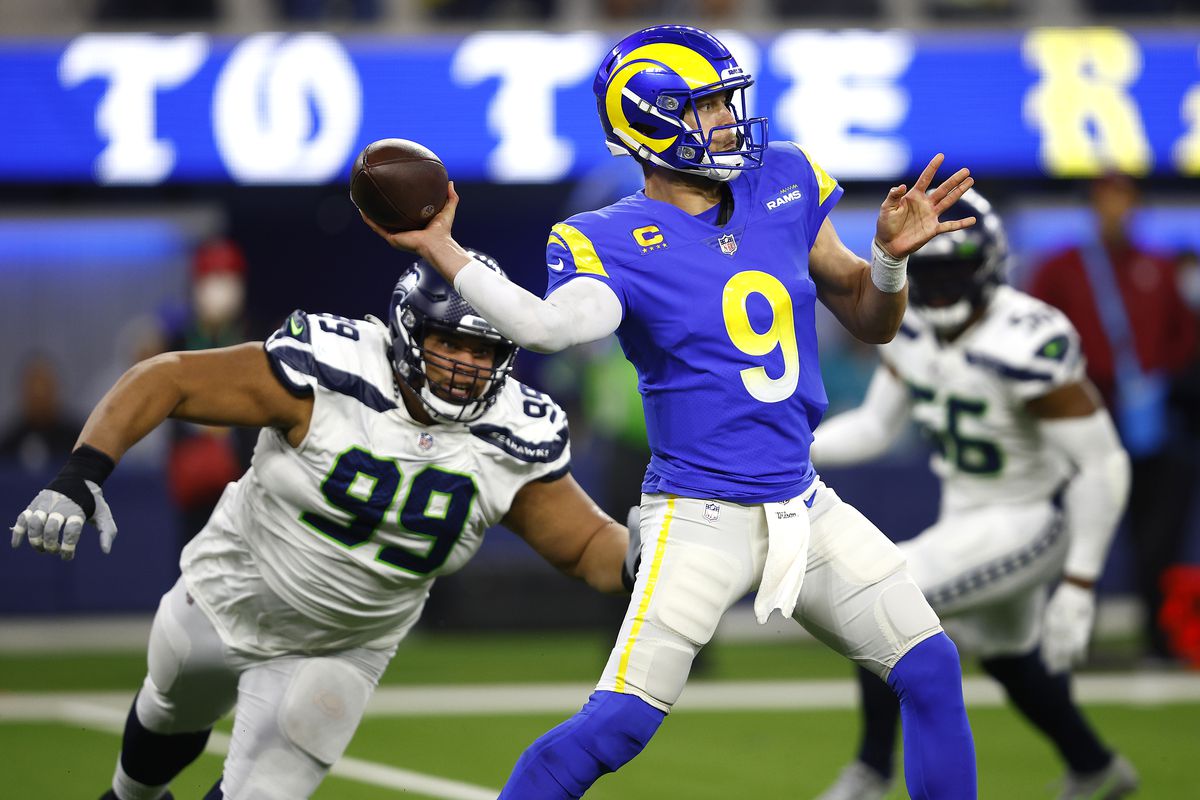 Matthew Stafford #9 of the Los Angeles Rams passes the ball during under pressure from Al Woods #99 of the Seattle Seahawks the first half of a game at SoFi Stadium on December 21, 2021 in Inglewood, California.
