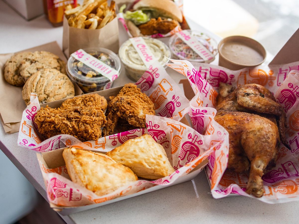 Baskets of fried chicken and biscuits beside an assortment of cookies, french fries, and fried chicken sandwich