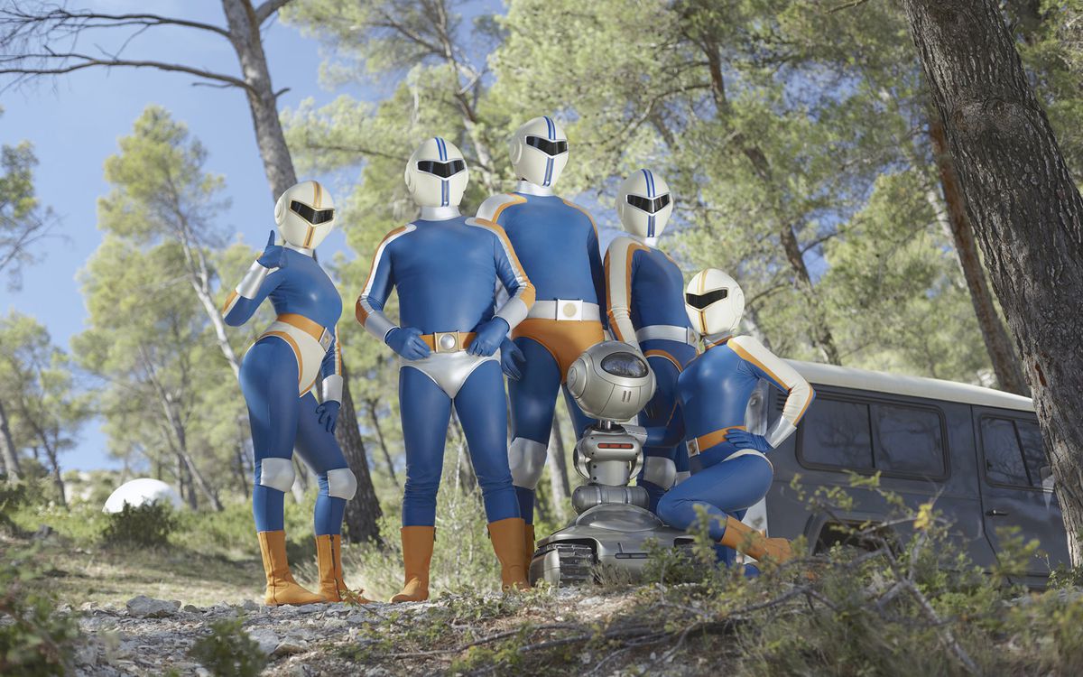 The five superheroes of Tobacco Force and their robot sidekick pose on a wooded hill in a still from Smoking Causes Coughing