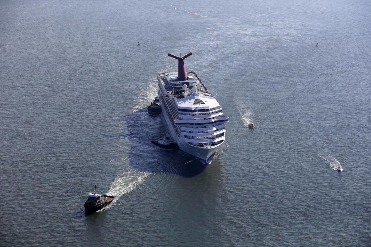 This Feb. 14, 2013 file photo shows the disabled Carnival Lines cruise ship Triumph being towed to harbor off Mobile Bay, Ala. Carnival Cruise Lines on Wednesday, April 17, announced a $300 million program to add emergency generators, upgrade fire safety 