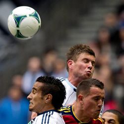 Real Salt Lake's Luis Gil, right, and Vancouver Whitecaps' Camilo Sanvezzo, left, of Brazil, and Brad Rusin, top, vie for the ball during the first half of an MLS soccer game in Vancouver, British Columbia, on Saturday April 13, 2013.