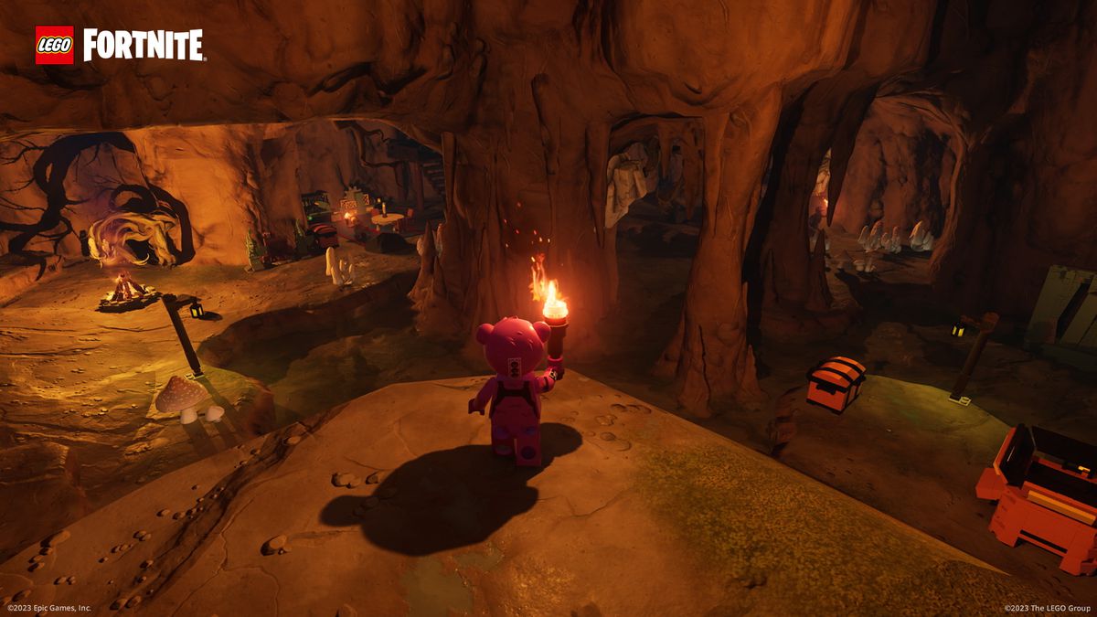 Cuddly Team Leader, in Lego minifig form, holds a torch and looks down upon an underground cavern in a screenshot from Lego Fortnite