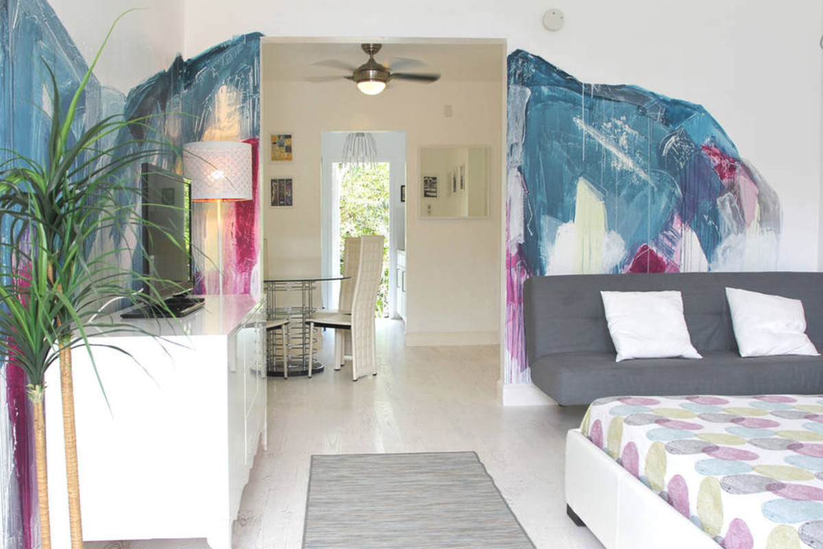 A studio on airbnb in Miami Beach with a wall mural and white modern interiors