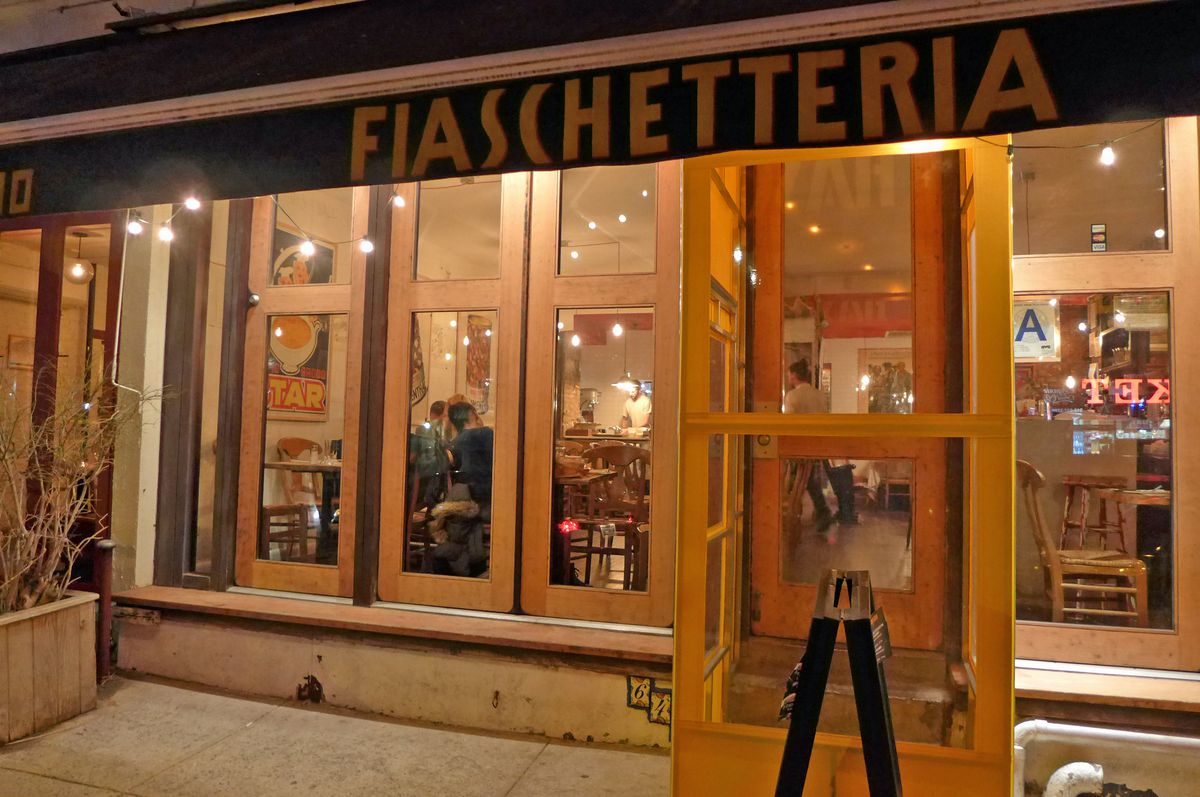 The exterior of Fiaschetteria Pistoia, with floor to ceiling window panels that give a view into the restaurant