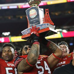 Utah Utes offensive lineman Isaac Asiata (54) lifts the champions trophy as the Utes defeat the Hoosiers in the Foster Farms Bowl in Santa Clara, California, on Wednesday, Dec. 28, 2016.