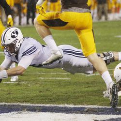 Brigham Young Cougars quarterback Tanner Mangum (12) scores on a dive into the end zone against the Wyoming Cowboys during the Poinsettia Bowl in San Diego on Wednesday, Dec. 21, 2016.