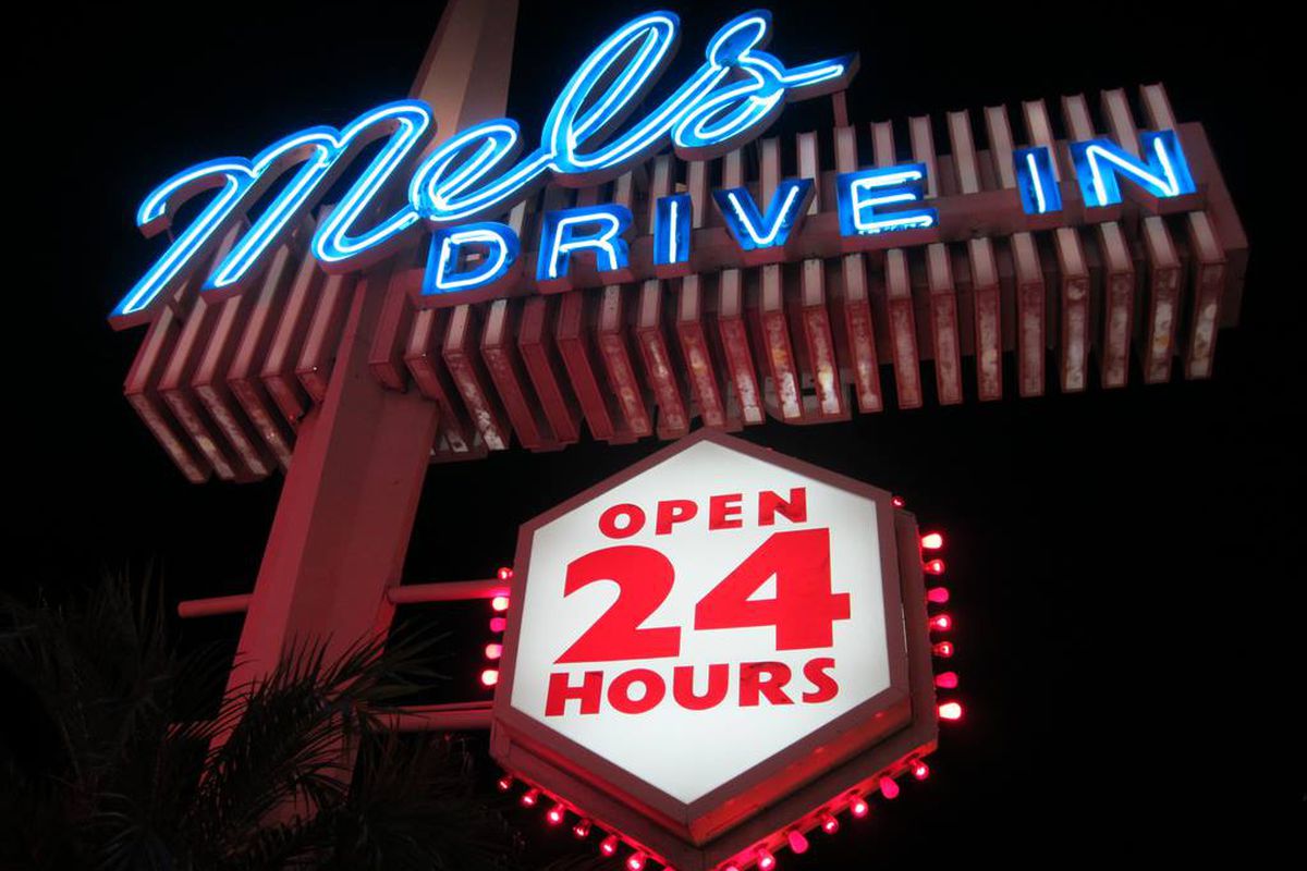 Mel’s Drive-In sign glows with neon at night.