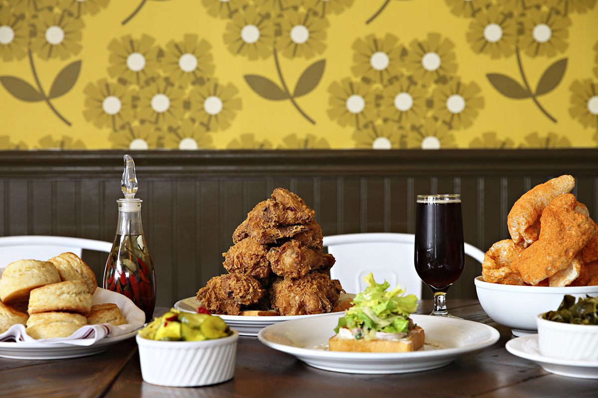 A long table inside Revival’s Minneapolis location is set with two towers of fried chicken and a host of sides
