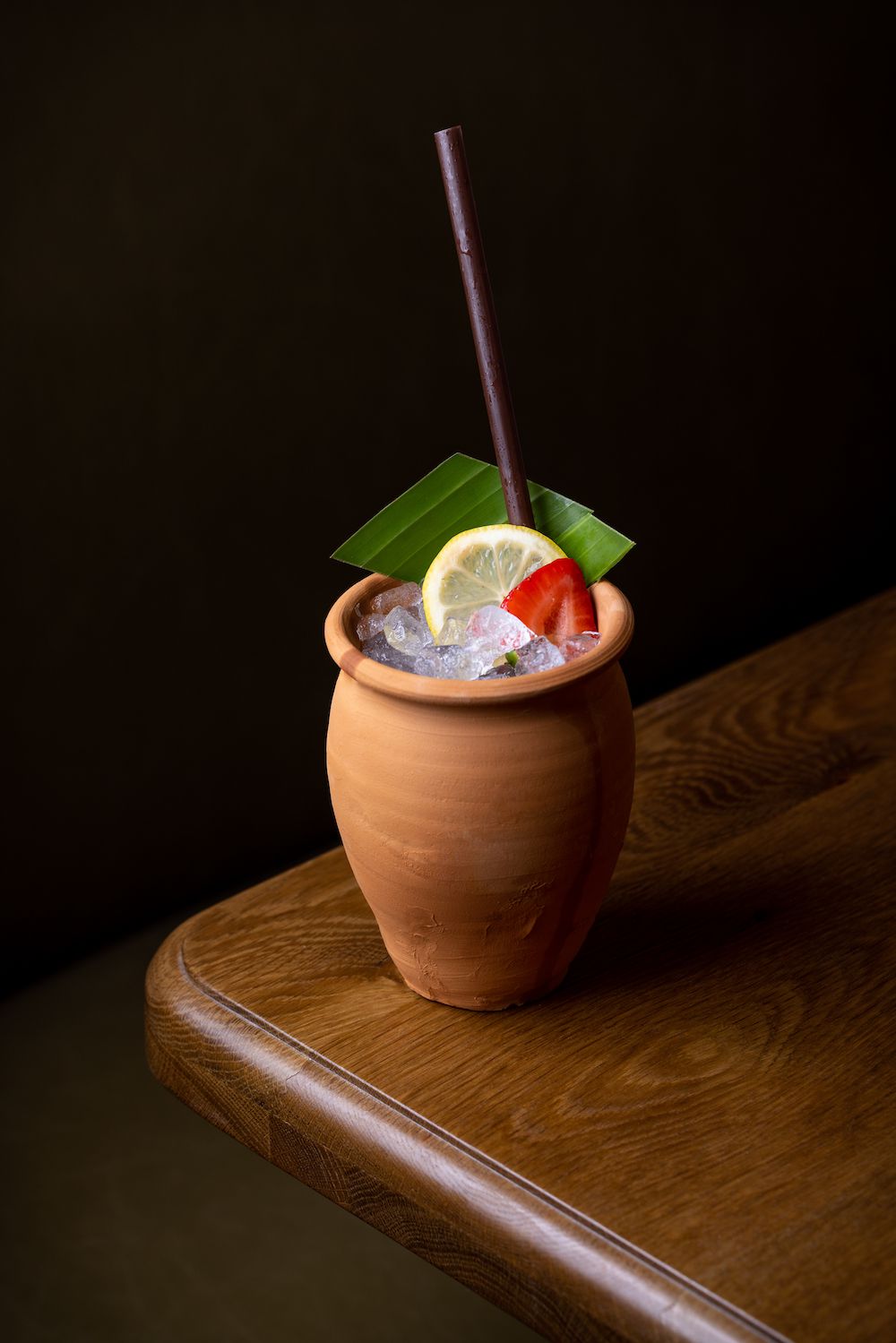 A cocktail in a terra cotta mug.
