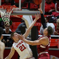 Utah Utes forward Tyler Rawson (21) is charged with a foul as Stanford Cardinal forward Reid Travis (22) lays it up at the Huntsman Center in Salt Lake City on Thursday, Feb. 8, 2018.