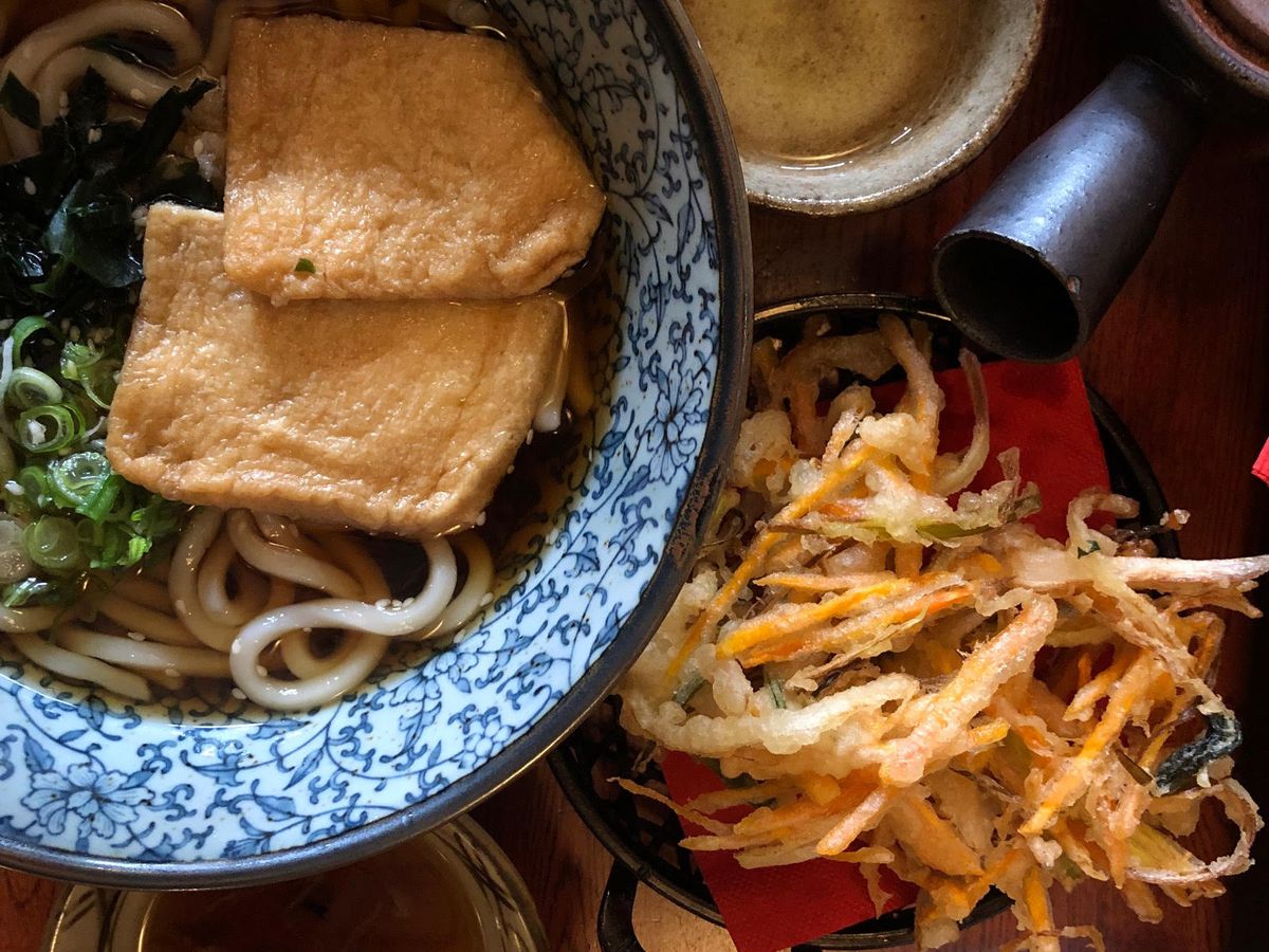 A bowl of udon with kakiage tempura alongside.
