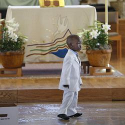 A wandering child in his Sunday suit as several hundred Sudanese, many of them "Lost Boys and Girls of Sudan,"   celebrate Easter with drums, dancing, food, and worship at All Saints Episcopal Church on Easter Sunday, March 31, 2013, in Salt Lake City.