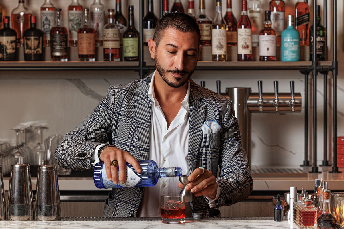 Carlo Splendorini pours a drink behind a bar.