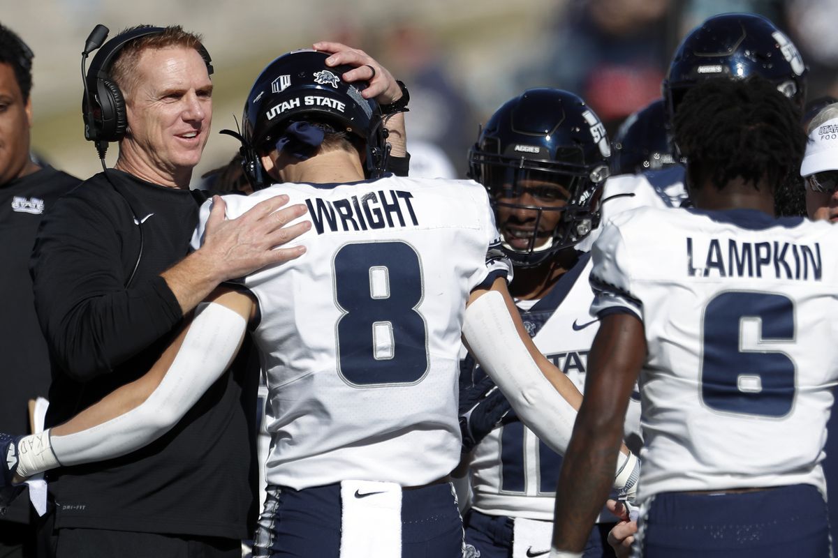 Utah State wide receiver Derek Wright is congratulated by coach Blake Anderson during game against New Mexico, Nov. 26, 2021.
