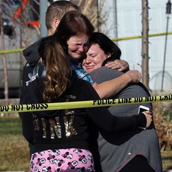People console each other at the scene of a fatal auto-pedestrian accident in Magna, Monday, March 7, 2016.