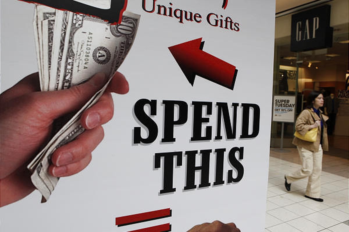 A shopper passes by an ad at NewPark Mall in Newark, Calif. Job worries have Americans concerned about the economy.