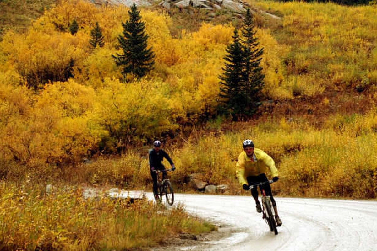 Two men bike down the Albion Basin road on a rainy fall day above Snowbird Sunday September 29, 2002. Officials have announced that Albion Basin Road in Little Cottonwood Canyon will open for the summer season on Thursday, July 4, 2013.