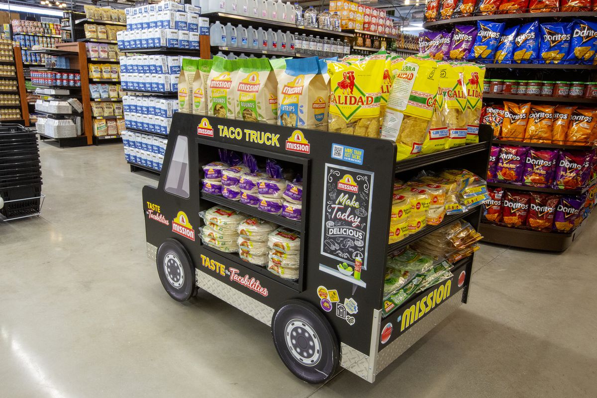 A small black truck-shaped display holds tortilla chips in bags.