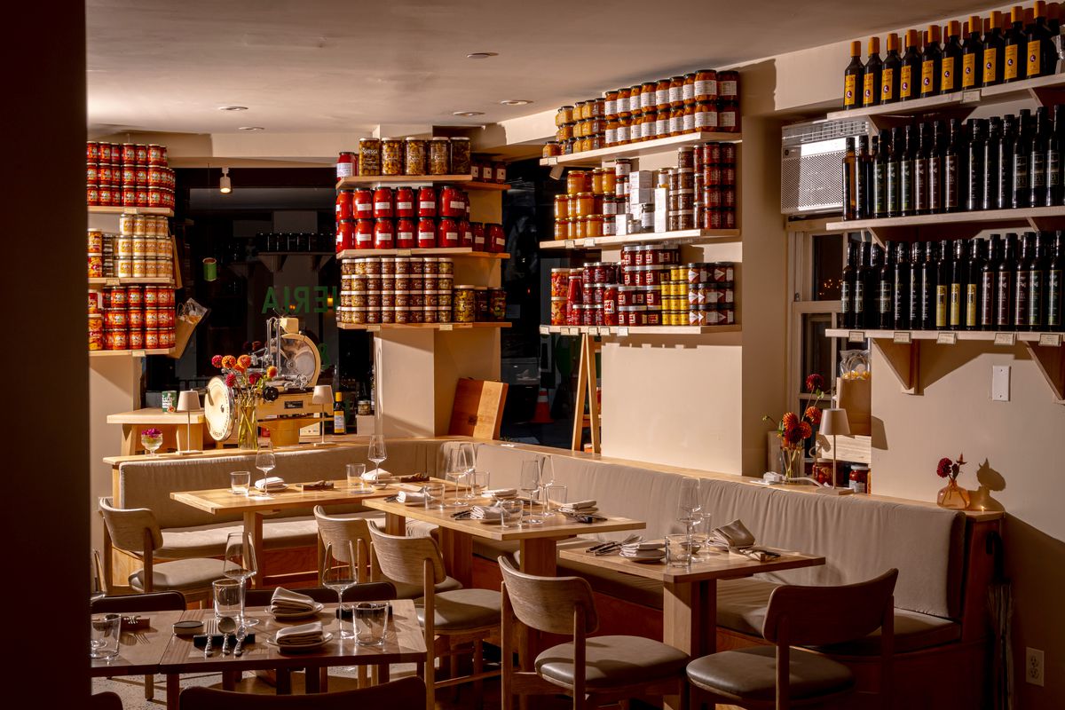 The dining area upstairs at Roscioli, with blonde seating and shelves lined with product.