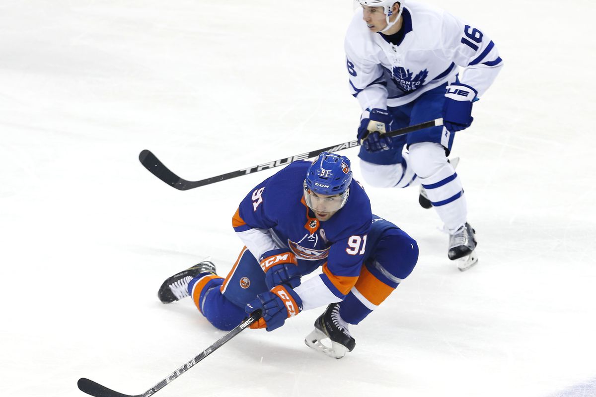 Mar 30, 2018; Brooklyn, NY, USA; New York Islanders center John Tavares (91) passes the puck against Toronto Maple Leafs center Mitchell Marner (16) during the second period at Barclays Center.
