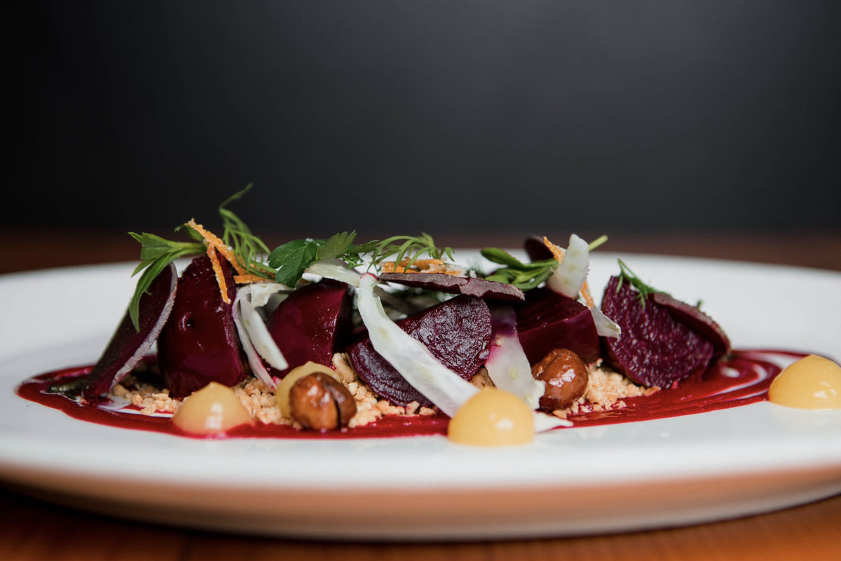 Roasted beets with citrus, fennel, and hazelnuts on a white plate at Local 360