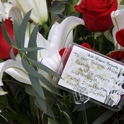 Flowers and a message from the Washington State Patrol Investigative Assistance Division are shown at a growing memorial outside the Tacoma Police Department headquarters Thursday, Dec. 1, 2016, in Tacoma, Wash. A Tacoma Police officer died Wednesday night at a hospital after being shot multiple times earlier in the day while answering a domestic violence call. 