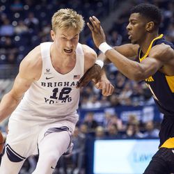 Brigham Young forward Eric Mika (12) drives to the hoop against Coppin State forward Izais Hicks (11) during an NCAA college basketball game in Provo on Thursday, Nov. 17, 2016.