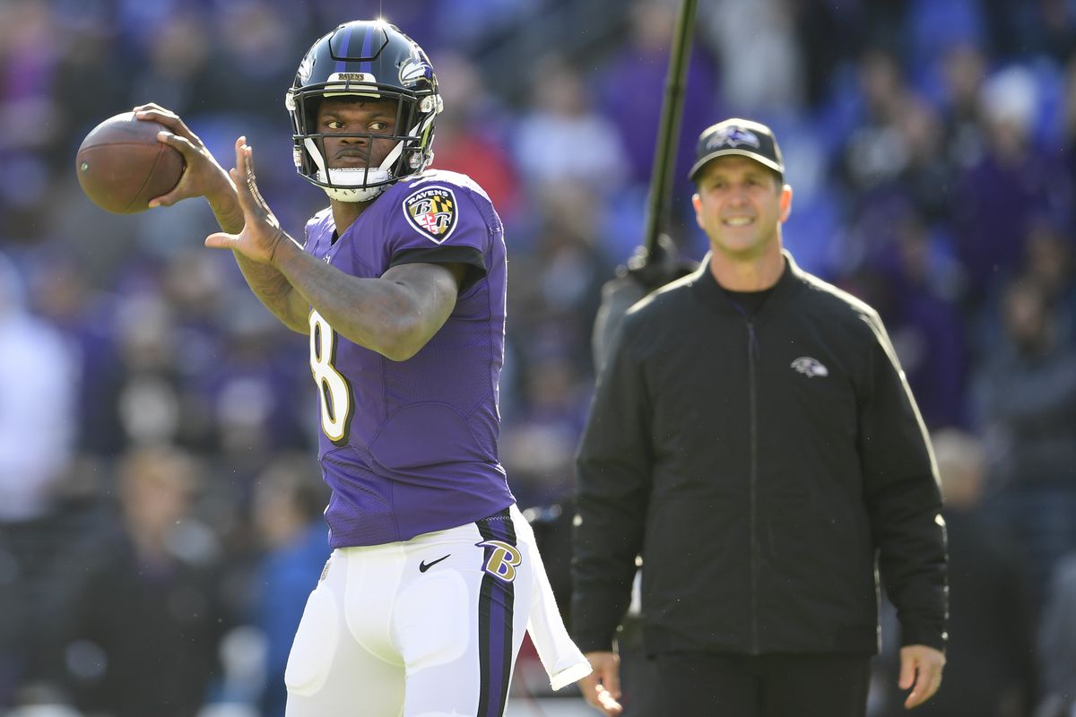 Baltimore Ravens quarterback Lamar Jackson passes as head coach John Harbaugh looks prior to the game against the Los Angeles Chargers in a AFC Wild Card playoff football game at M&amp;amp;T Bank Stadium.