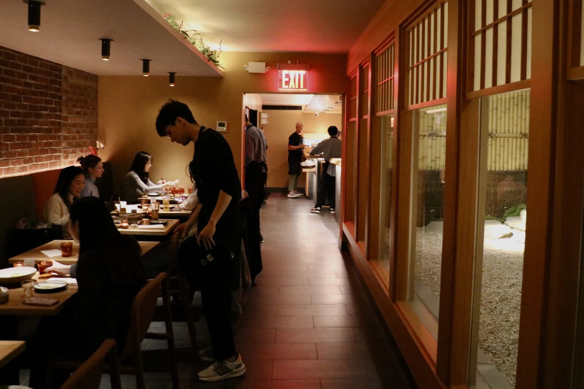 Customers sit in a dim dining room at Konban, a Japanese restaurant in Manhattan.