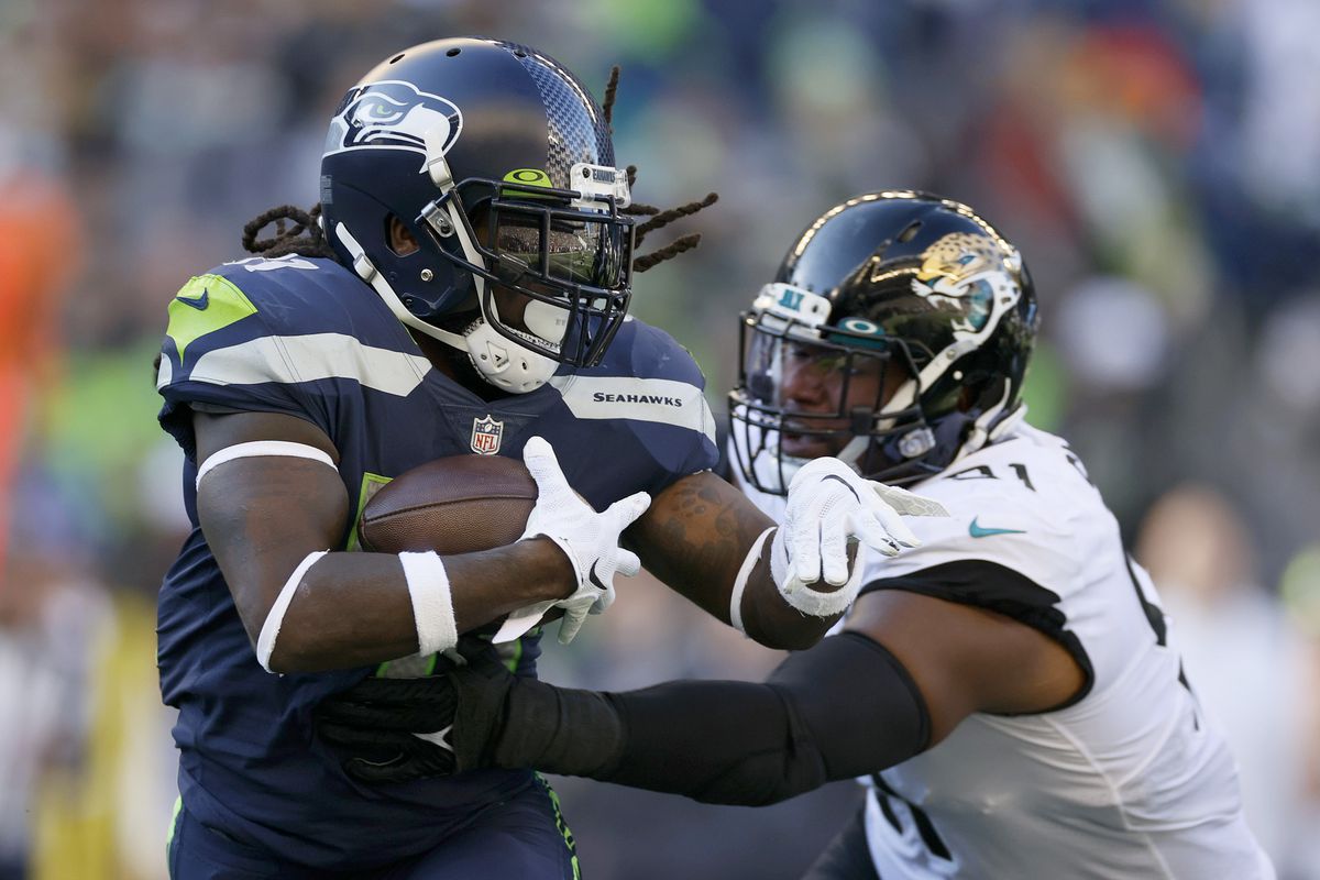 Alex Collins #41 of the Seattle Seahawks carries the ball against Dawuane Smoot #91 of the Jacksonville Jaguars during the third quarter at Lumen Field on October 31, 2021 in Seattle, Washington.