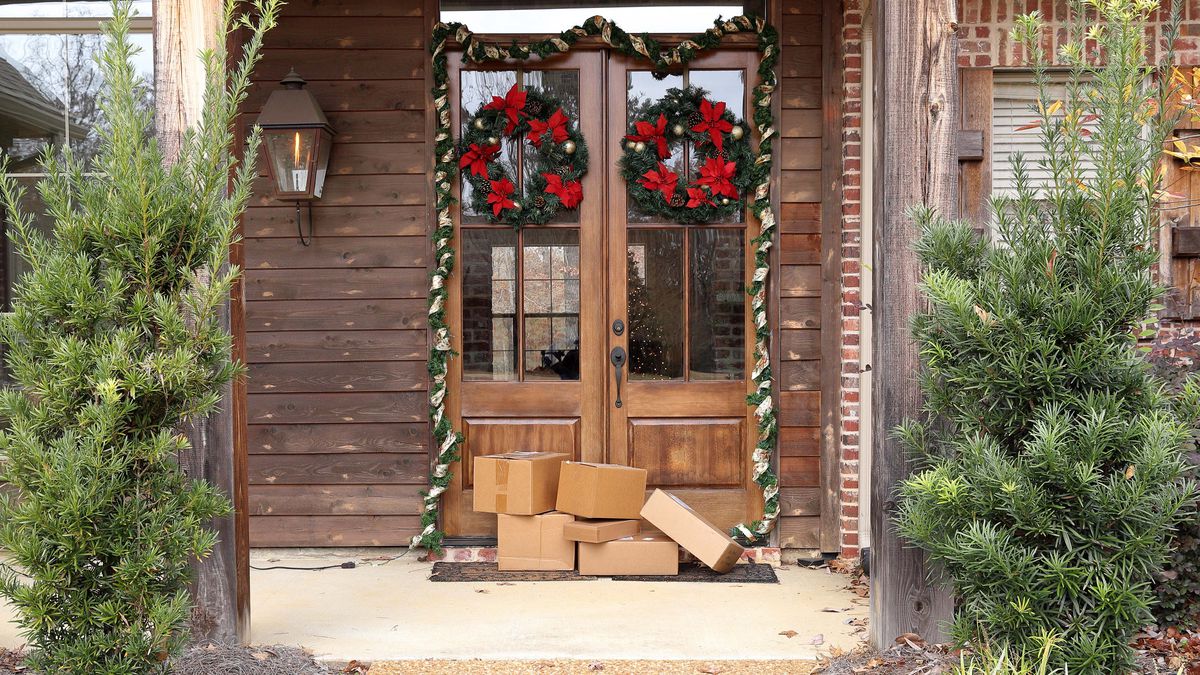 A door decorated for Christmas with packages at the door step.