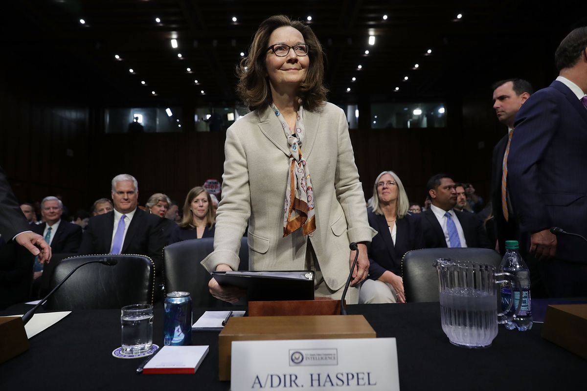 Haspel, wearing a khaki suit and a patterned scarf, appears before the Senate Intelligence Committee.