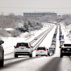 Traffic stacks up on 5300 South in Taylorsville as snow falls along the Wasatch Front on Friday, Dec. 10, 2021.