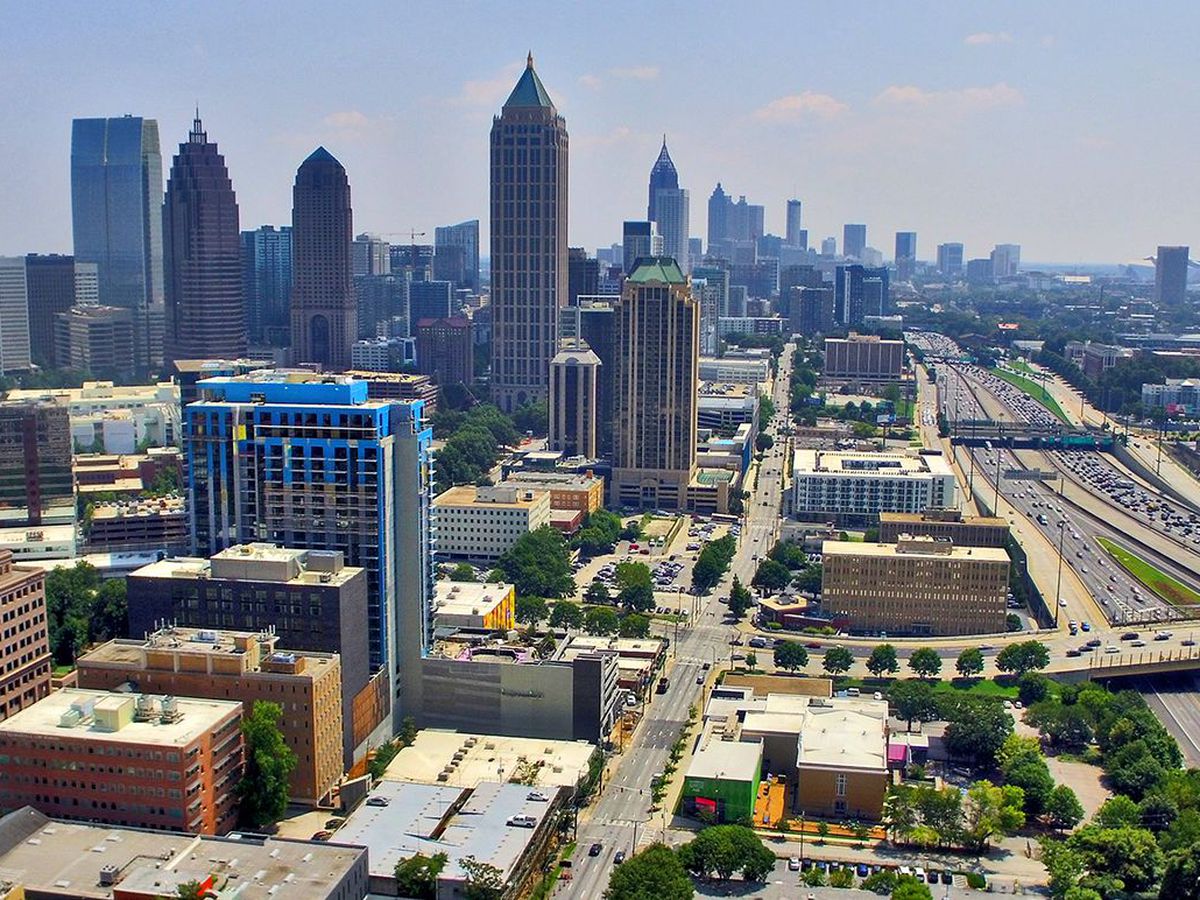 Aerial view of Midtown Atlanta, with a skyline at left and the highway to the right.